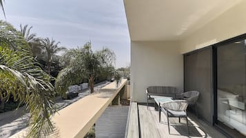 Un balcon avec un coin salon, une petite table et un canapé.