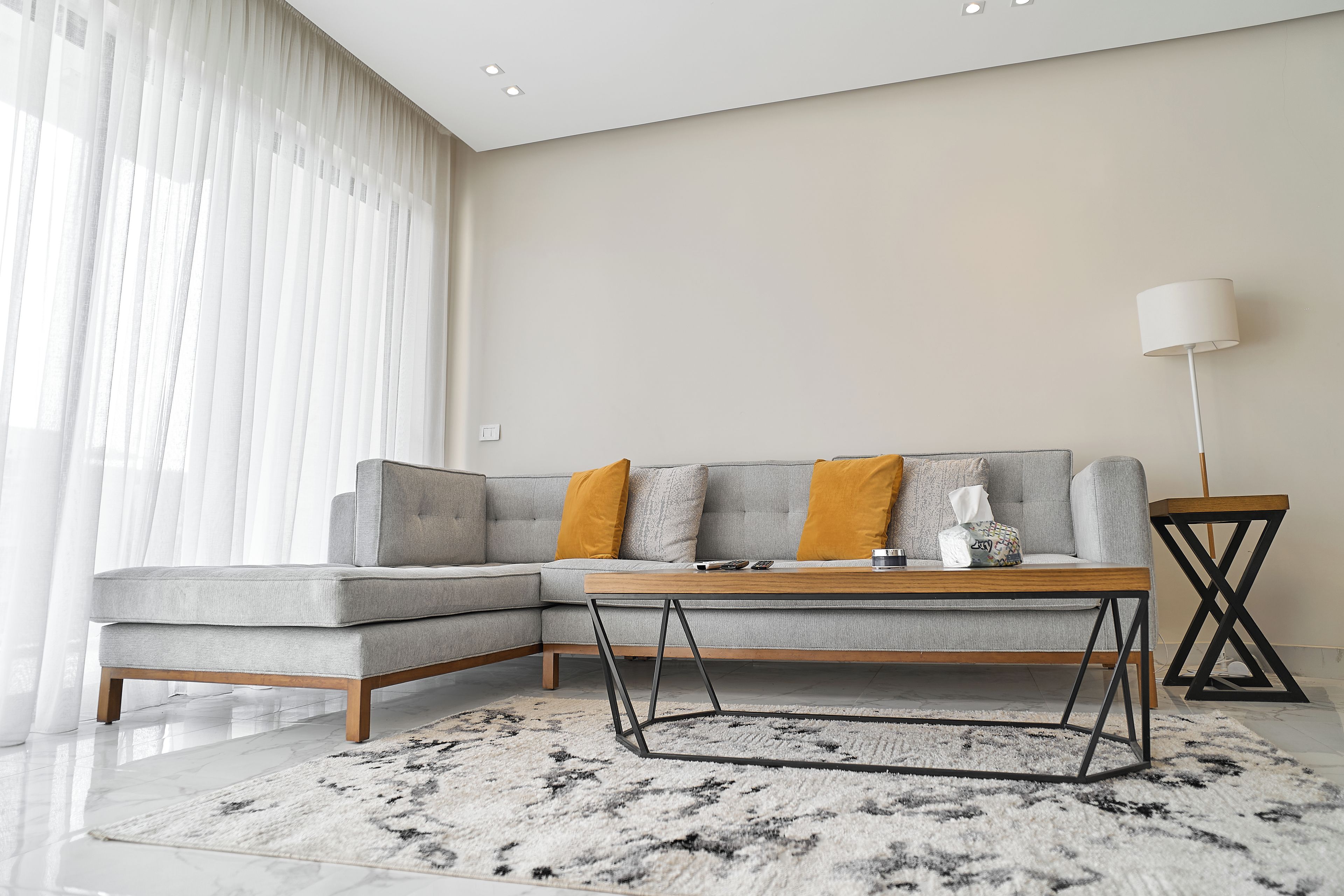 A modern living room with a sectional sofa, a coffee table, and a floor lamp.