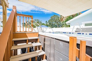 A pool area with a hot tub, wooden steps, and a covered seating area. - Paradise by the Gulf unit B-3 br/2 ba duplex close to beach (Indian Rocks Beach)