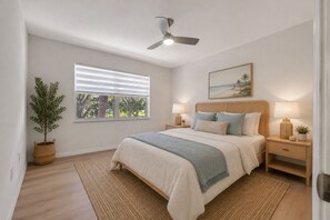 A bedroom with a bed, a ceiling fan, a window with blinds, a bedside table with a lamp, a potted plant, and a painting on the wall. -  55+ Gated Waterfront community Condo w/ Dock, Pool, and laundry on site (St. Petersburg)