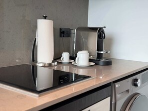 A modern kitchen with a coffee machine, a paper towel holder, and a microwave. - Stunning Studio at E11EVEN Residences Rooftop Pool (Miami)