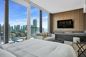 A modern hotel room with a large bed, a seating area, and a city view. - Luxury Downtown Miami Studio with Resort Amenities (Miami)