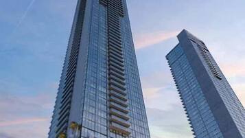 Two tall, modern skyscrapers with reflective glass facades and a clear sky in the background.