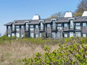 A modern multi-story building with balconies, large windows, and a flat roof. - 4 Star Holiday Home in Martofte (Martofte)