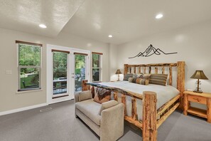 Ein Schlafzimmer mit einem Holzbett, einer Couch und einer Lampe.