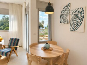 A dining area with a round table, chairs, and a pendant light. - Port city haifa - Sea front 1 bdrm apt w/ mamad (Haifa)
