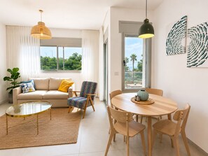 Una sala moderna con sofá, sillón, mesa de centro, mesa de comedor y sillas.