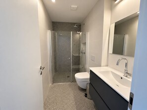 A modern bathroom with a shower, toilet, and vanity. - Port City Haifa - Downtown lux 1 Bedroom 3 (Haifa)