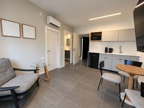 A modern kitchen with a dishwasher, microwave, and a coffee maker on the counter. - Port City Haifa - Downtown lux 1 Bedroom 3 (Haifa)