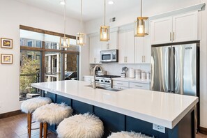 A modern kitchen with a large island, stainless steel appliances, and pendant lighting. - Luxury 2BR Canyons Village Condo: Walk to Lift, Pool, Hot Tub & Viking Kitchen (Park City)