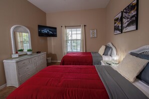 A bedroom with a large bed, a dresser, a television, and a window with curtains. - 3BR Disney Gataway/Bahama Bay Resort/Davenport FL (Davenport)