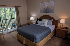 A bedroom with a large bed, two bedside tables with lamps, a window with curtains, a balcony with a chair, and a painting on the wall. - 3BR Disney Gataway/Bahama Bay Resort/Davenport FL (Davenport)