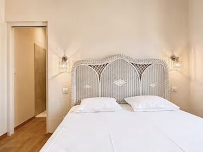 Une chambre à coucher avec un lit, deux tables de chevet et une porte.
