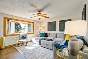 A living room with a ceiling fan, a sofa, a chair, and a lamp. - Pikes Peak Retreat | Hot Tub, Firepit + Pets (Colorado Springs)