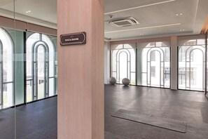 A yoga room with a sign, large windows, and exercise balls. - Title Legendary Apartment by TVC (Tambon Choeng Thale)