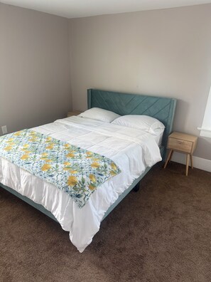 A bedroom with a bed, a nightstand, and a window. -  Spacious 3BR Retreat Minutes from Water & Downtown (Erie)