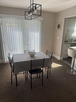 A dining area with a table, chairs, a bowl, and a modern light fixture. -  Spacious 3BR Retreat Minutes from Water & Downtown (Erie)