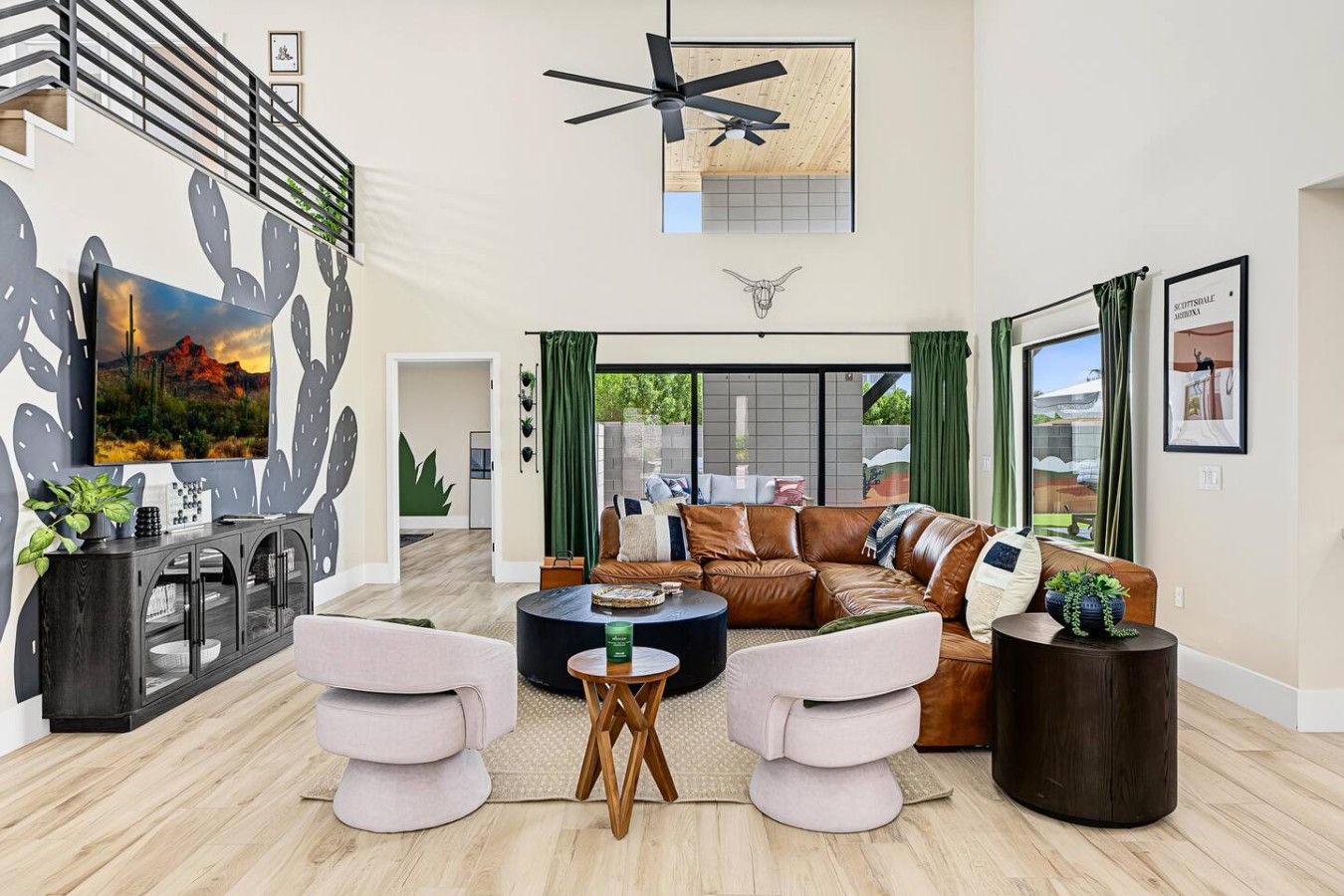 A spacious living room with a large sofa, a coffee table, and a TV mounted on the wall.