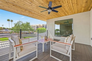 A balcony with outdoor seating, a ceiling fan, and a view of the surrounding area. - Casa Saguaro Old Town: 6BR Heated Pool Hot Tub (Scottsdale)