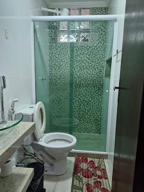 A bathroom with a toilet, a glass shower enclosure, and a sink. - Cozy family home where you can have good conversation and good food, good conversation and the beach. (Armação dos Búzios)