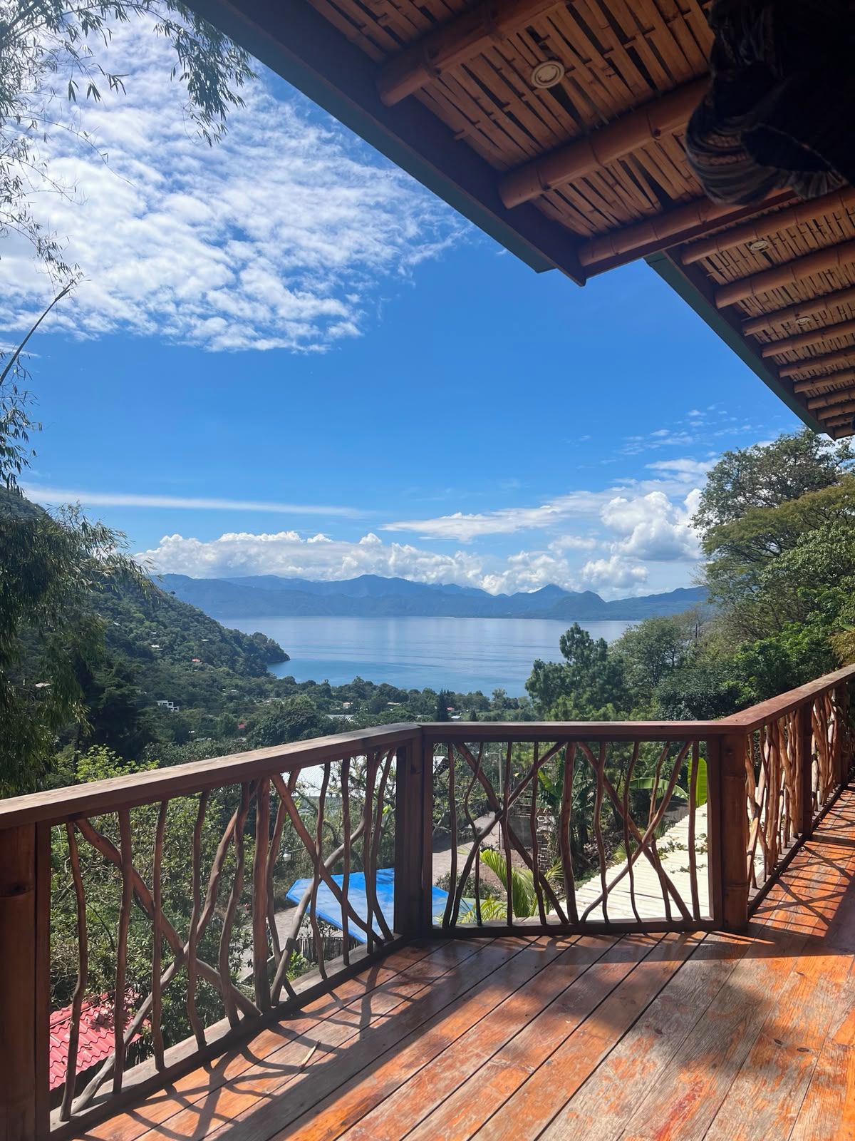 A wooden deck with a view of a lake and mountains.