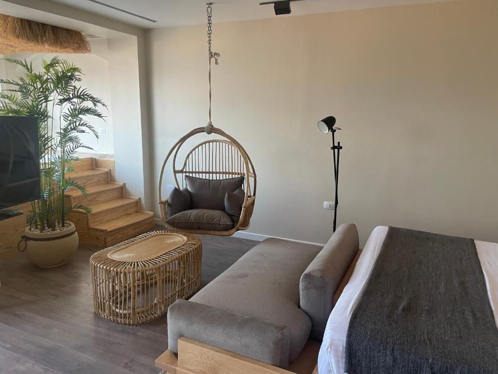 Uma sala de estar moderna com um sofá, uma cadeira suspensa, uma planta em vaso e uma escada.