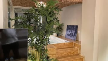 Una escalera de madera lleva a una habitación con una bañera y un cuadro en la pared.