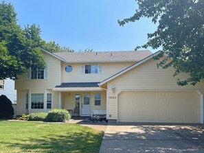 A two-story house with a garage, a front porch, and a well-maintained lawn. - Family-Friendly Corvallis Home Near OSU & Parks (Corvallis)