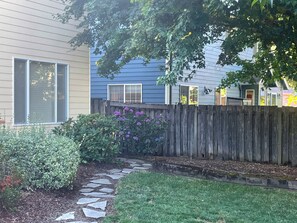 Un quartier résidentiel avec un sentier en pierre menant à une maison entourée d’une clôture en bois.