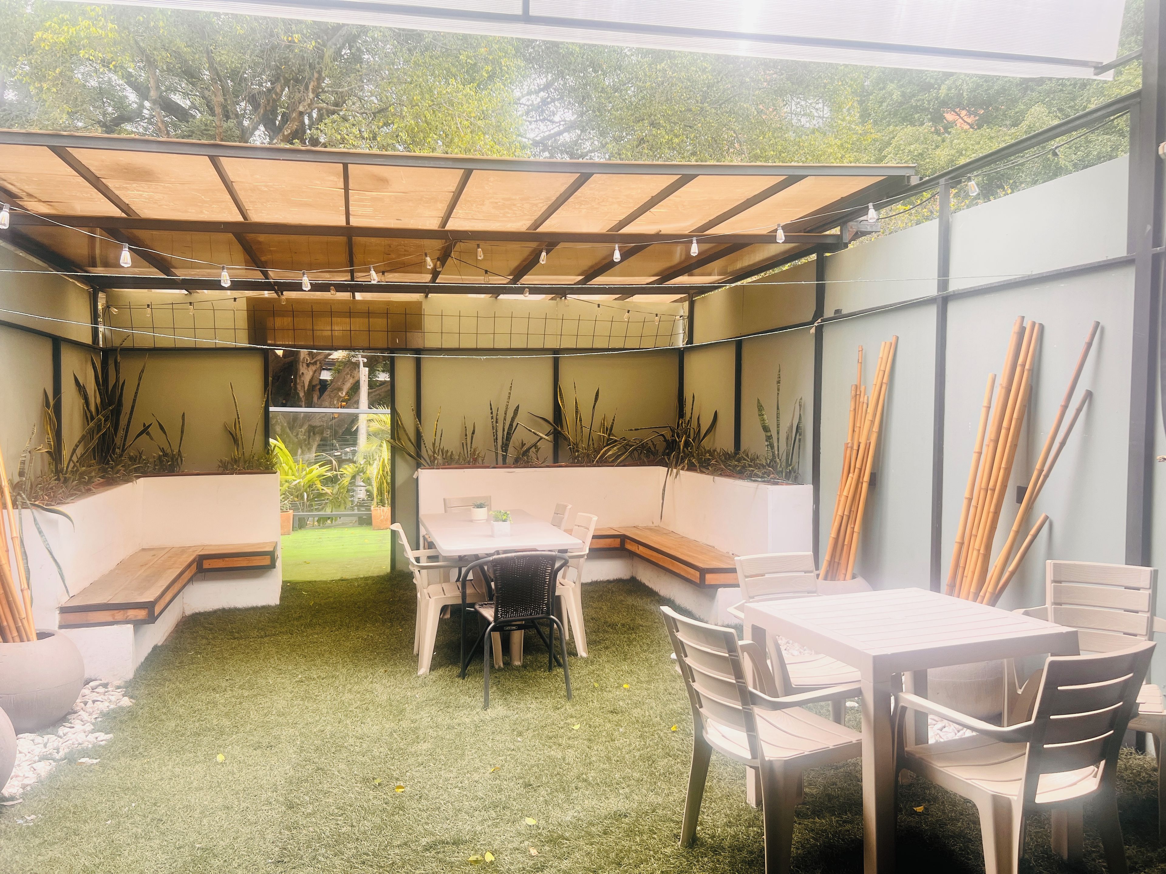 Une terrasse extérieure dotée d’une pergola en bois, de sièges et d’une table.
