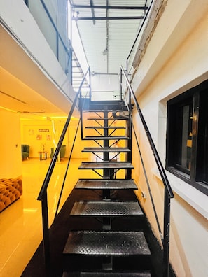 Eine Treppe mit Metallgeländern, die zu einer oberen Etage führt.