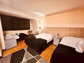 Ein Hotelzimmer mit zwei Betten, einem Schreibtisch, einem Stuhl und einem Nachttisch.