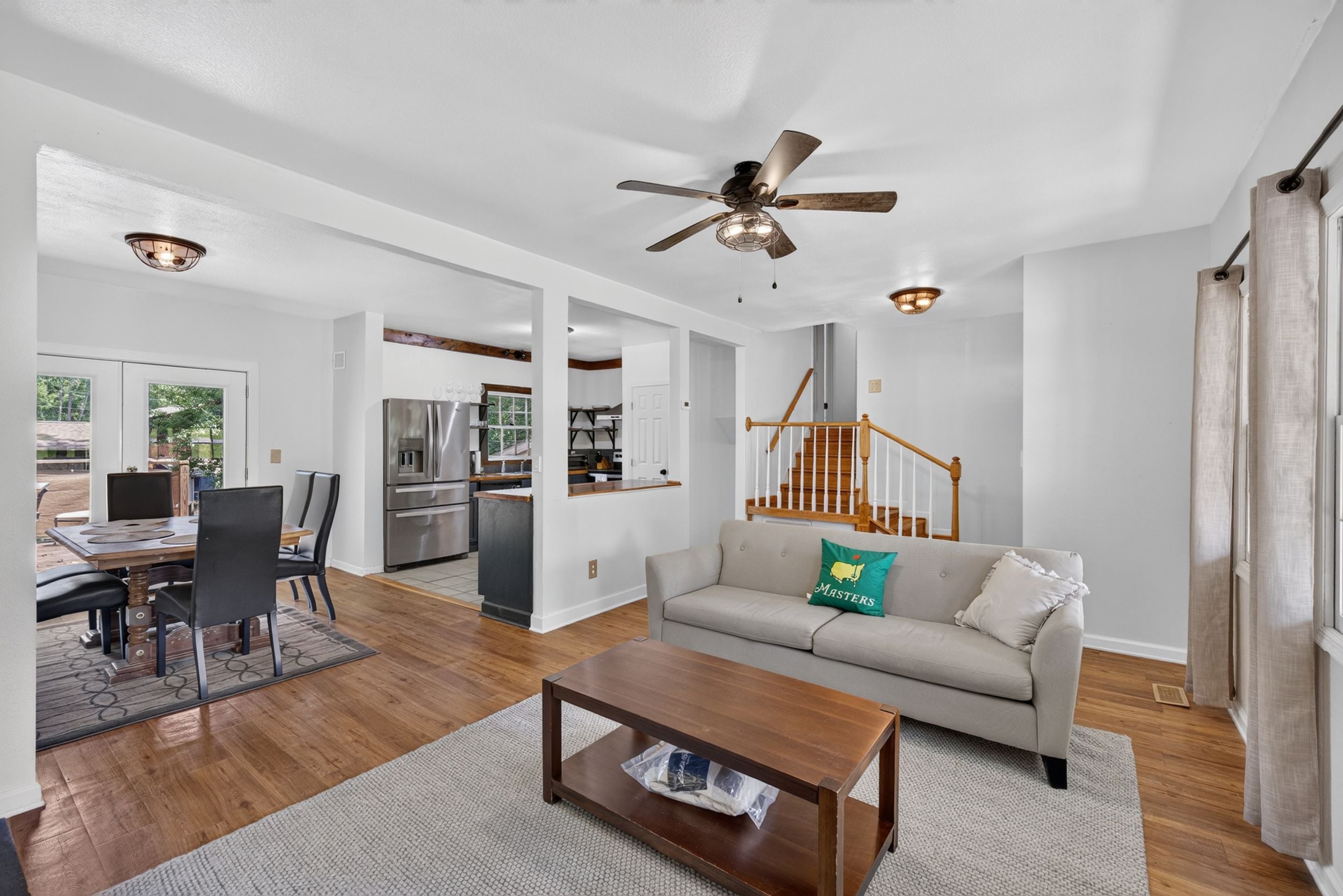 Tilava olohuone, jossa on sohva, sohvapöytä sekä ruokailutila tuoleineen ja pöytineen.