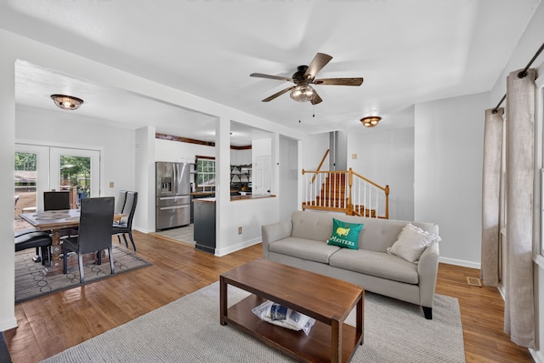 A spacious living room with a sofa, coffee table, and a dining area with chairs and a table.