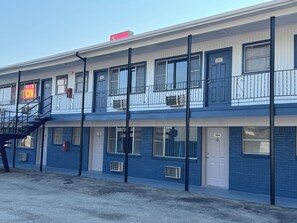 A multi-story building with a fire escape, numbered doors, and balconies with railings. - Sands Motel (Mount Pleasant)