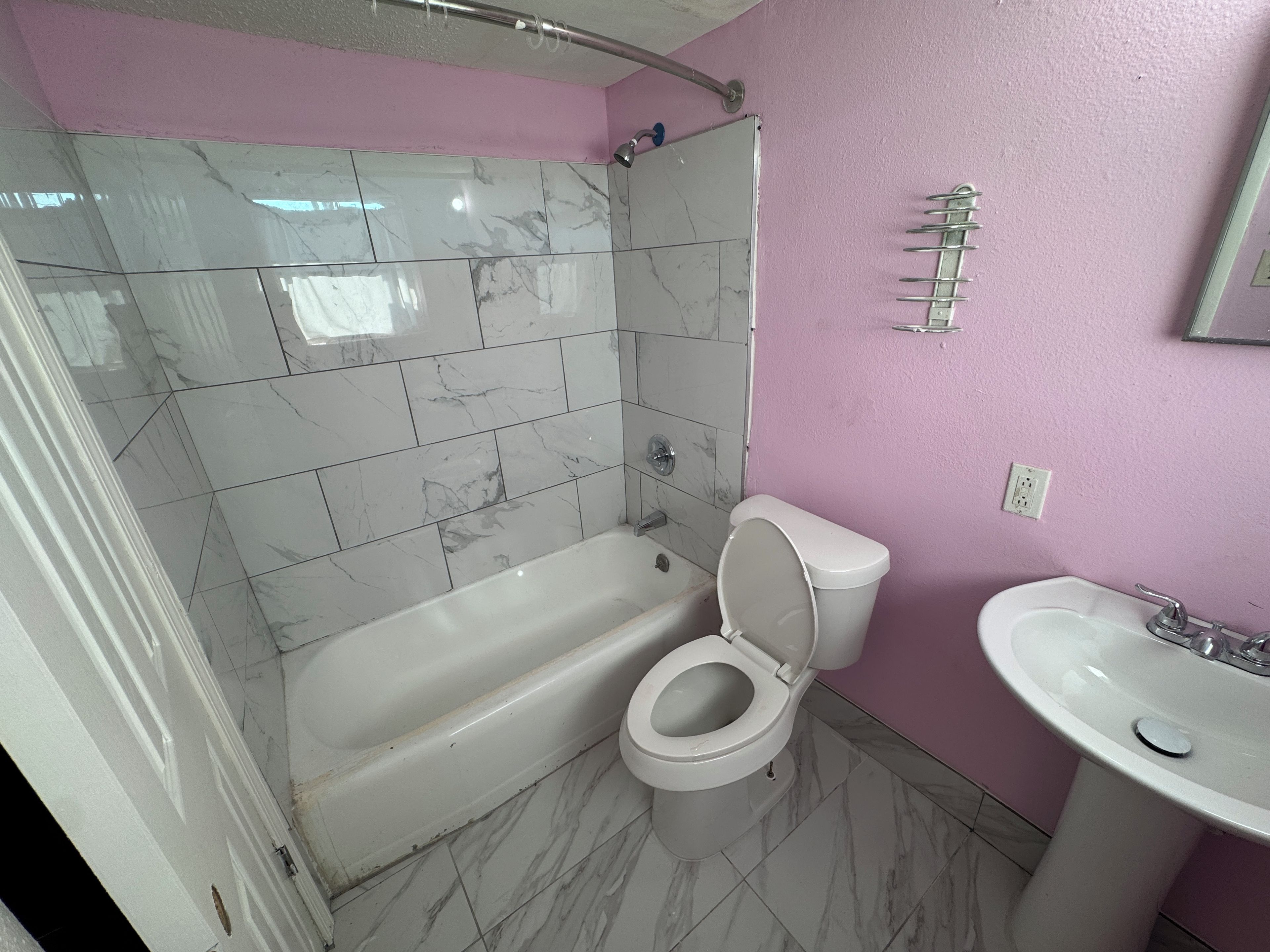 Ein Badezimmer mit einer Badewanne, Toilette und Waschbecken.