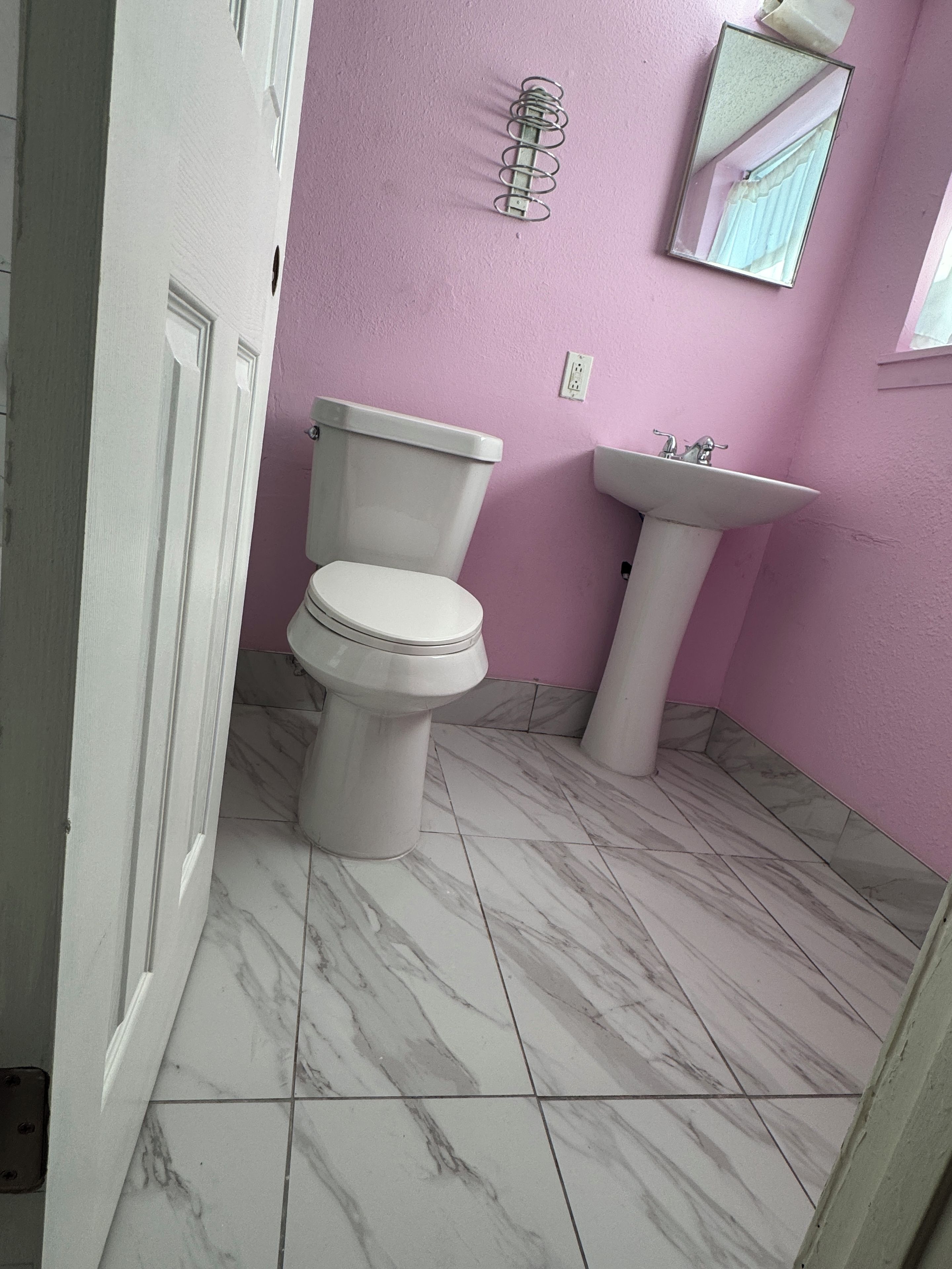 Une salle de bain avec des toilettes, un lavabo et un sol en marbre.