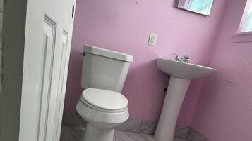 Une salle de bain avec des toilettes, un lavabo et un sol en marbre.
