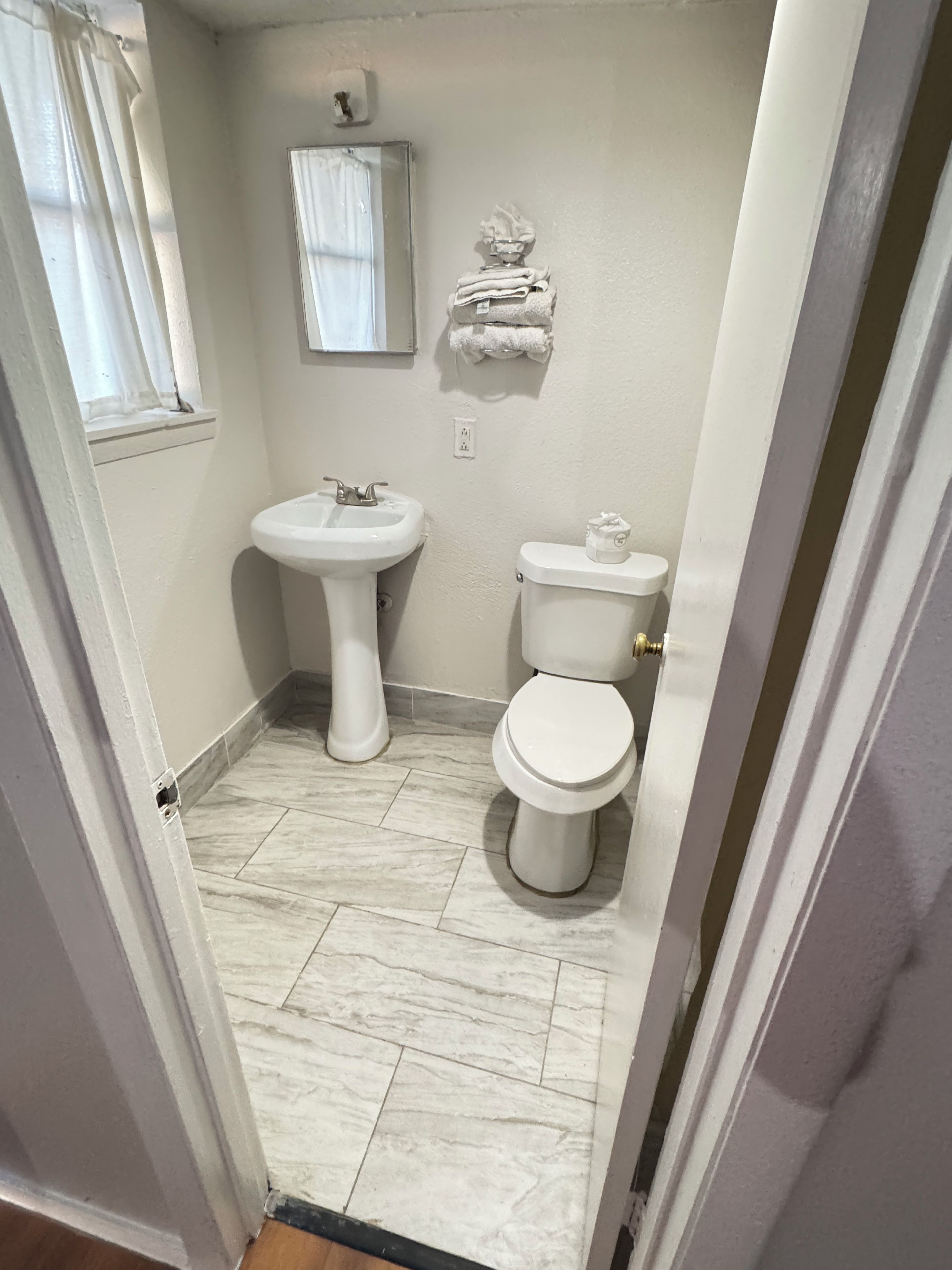 Un baño con lavamanos, inodoro y espejo.