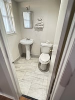 A bathroom with a sink, toilet, and a mirror.