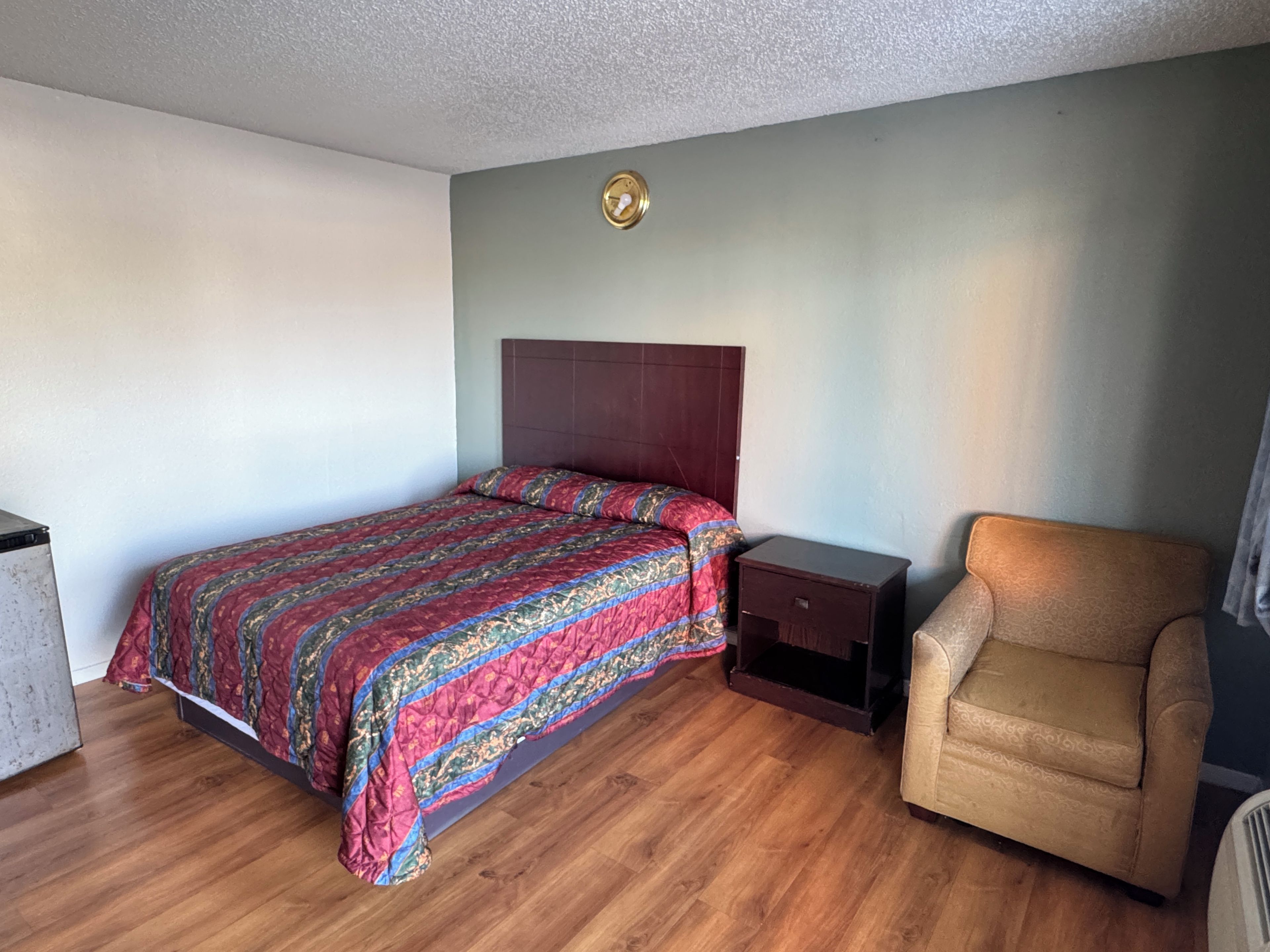 Une chambre à coucher avec un lit, une table de chevet, une chaise et une petite table.