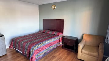 Une chambre à coucher avec un lit, une table de chevet, une chaise et une petite table.