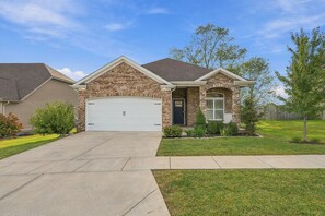 A residential house with a brick facade, a garage, and a well-maintained lawn. - Kentucky Getaway/Hot Tub (Georgetown)