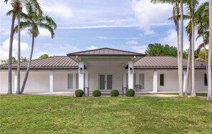 A modern building with a flat roof, a covered entrance, and a symmetrical facade. - Luxury Pool Villa (Palmetto Bay)