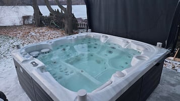 Een bubbelbad in een open omgeving, met een meer op de achtergrond.