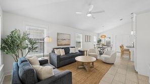 A modern living room with a grey sofa, a round coffee table, and a ceiling fan. - Private Pool Oasis on PCB West End | Short Walk to Beach | Bikes | Sleeps 8 (Panama City Beach)