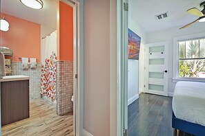 Ein Hotelzimmer mit Bett, Badezimmer mit Dusche und Blick ins Freie.