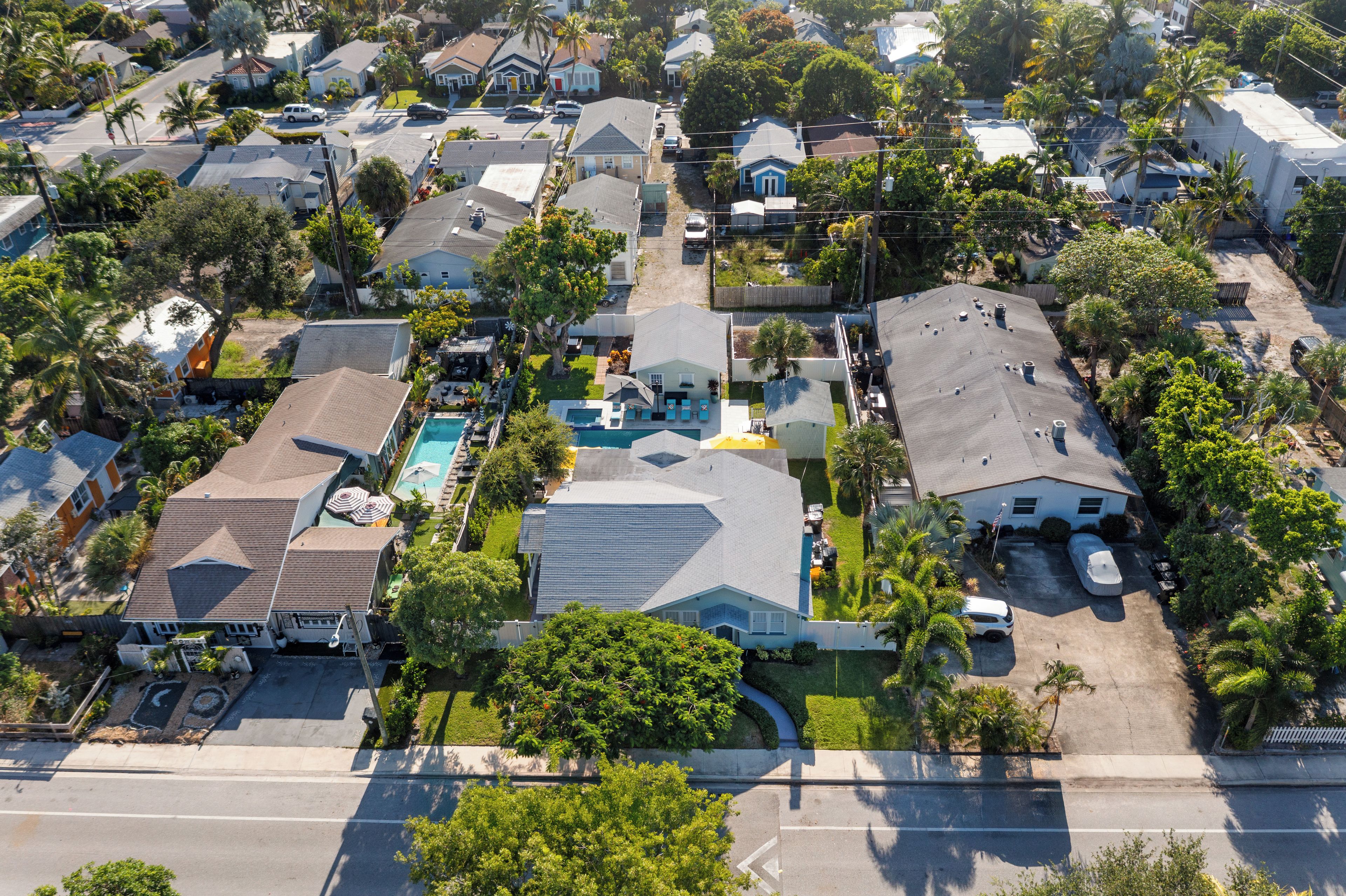 An aerial view of a residential neighborhood with houses, a swimming pool, and a street.