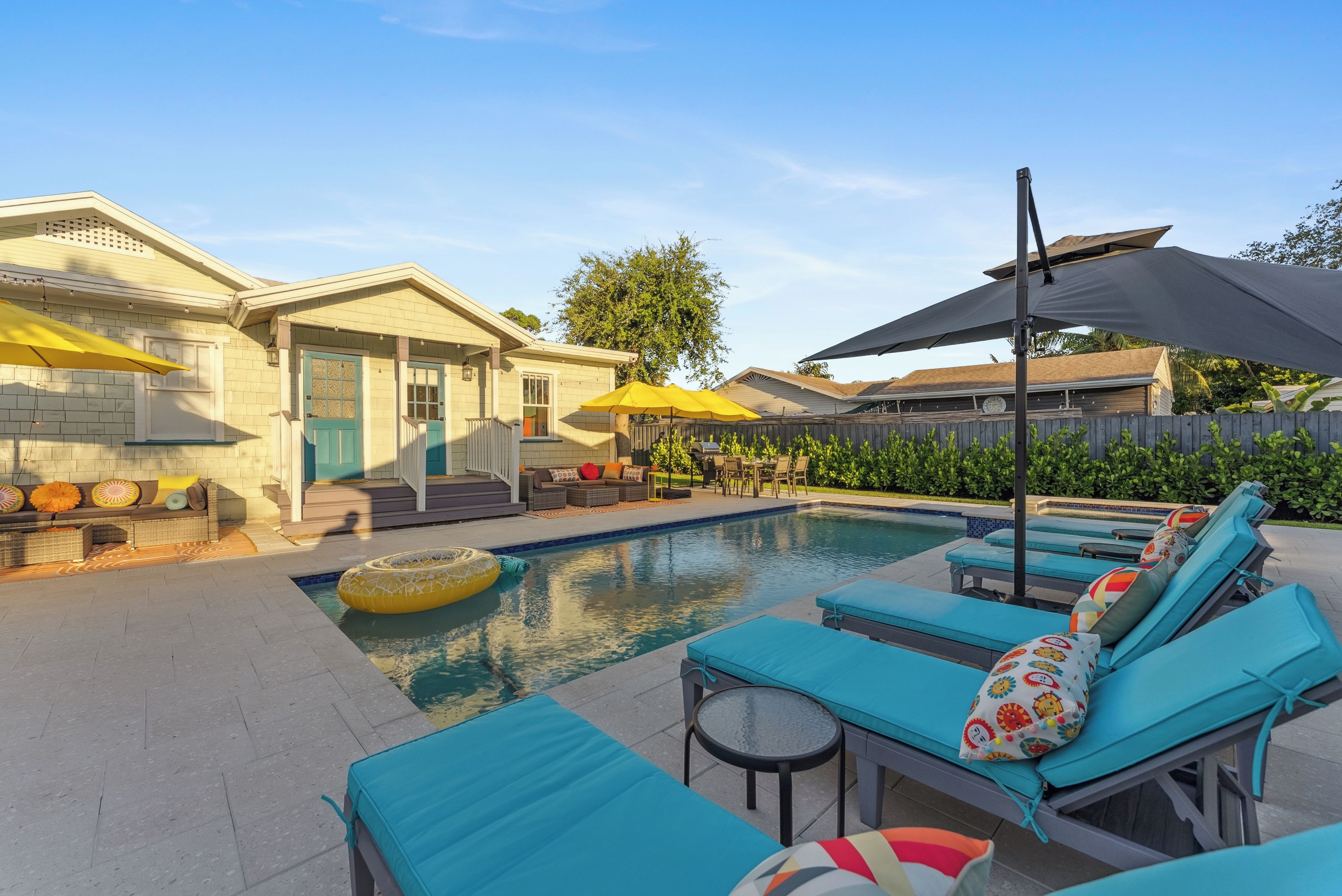 A pool area with lounge chairs, umbrellas, and a small pool.