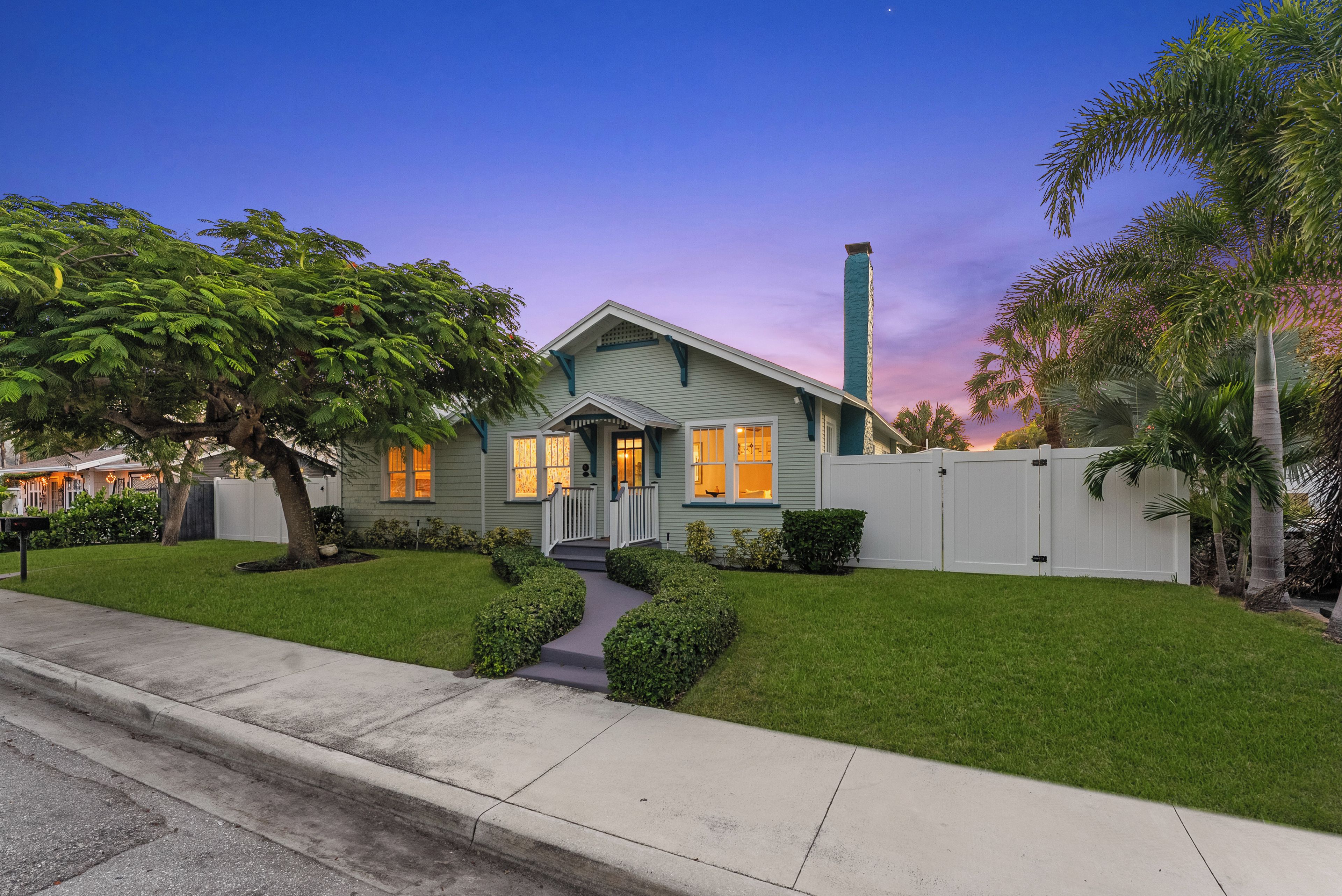 A two-story house with a front porch, a chimney, and a well-maintained lawn.
